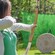 A woman with a bow and arrow aiming for an archery target